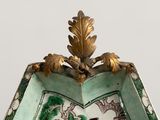 a green and white plate with a gold decoration on it