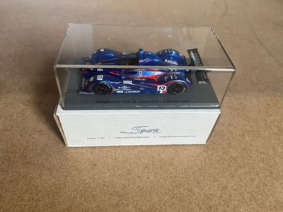 a blue toy car in a clear box on the floor