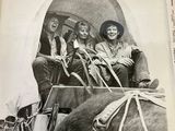 black and white photograph of a group of people riding in a horse drawn carriage
