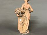statue of a woman with a basket of flowers