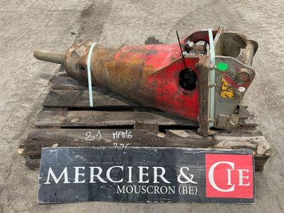 un gros objet métallique posé sur une palette à côté d'un panneau