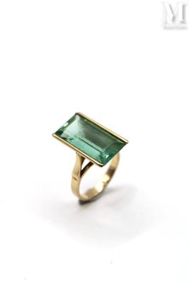 a close up of a ring with a green stone on it