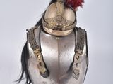 un casque argenté surmonté d'une plume rouge, posé sur un mannequin