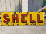 a yellow sign that says shell on the side of a building