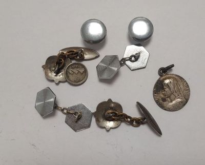 Plusieurs paires de boucles d'oreilles et une pièce de monnaie sont posées sur une table