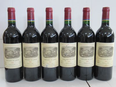 six bouteilles de vin sont alignées sur une table