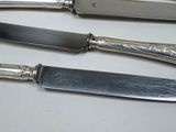 three knives and a knife holder on a table