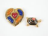 a turtle and a heart shaped brooch on a white surface