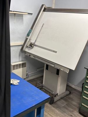 une table bleue sur laquelle se trouve un tableau blanc, dans une pièce