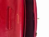the inside of a red purse with gold hardware