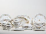 a group of white and gold plates and cups and saucers