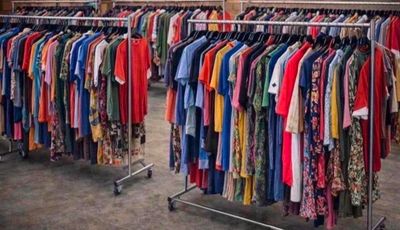 a lot of clothes hanging on a rack in a room