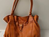 un sac à main marron posé sur une table blanche