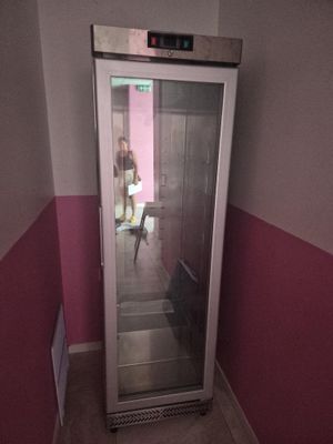 a person standing inside of a glass door in a room