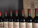 several bottles of red wine are lined up on a shelf
