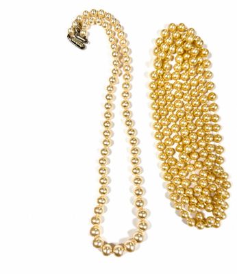 gold pearl necklace and bracelet set on a white background