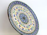 a close up of a decorative plate on a stand on a white background