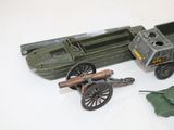a toy army vehicle and other toy vehicles on a white surface