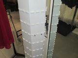 a tall white tower with a bottle of wine on top of it