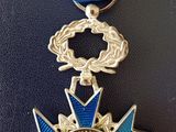 médaille avec un ruban bleu et un ruban bleu qui l'entoure, sur un fond noir