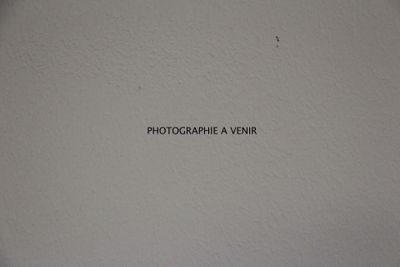une affiche sur le mur indiquant « Photographe : un centime »