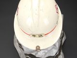 a white hard hat with a red stripe on it