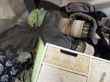 a box of clothes and a bottle of wine on a bed