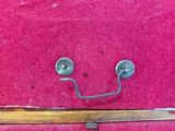 une valise rose sur laquelle est dessiné un smiley