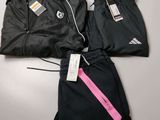 two pairs of black and pink tracksuits with tags on them