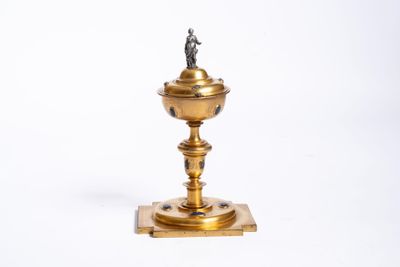 un bougeoir doré surmonté d'une statuette