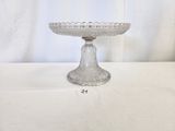 a glass cake plate on a table with a white background