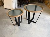 pair of round side tables with glass tops and metal legs
