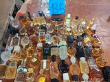 many bottles of perfume on a table with a price tag