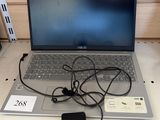 a laptop that is sitting on a table with a charger
