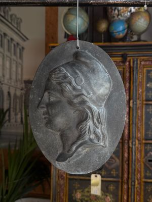a silver medallion with a woman ' s face on it