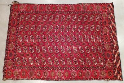 a red rug with a pattern on it on a white surface