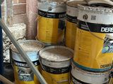 several buckets of paint sitting on a shelf in a room