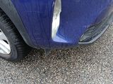 a close up of a blue car with a denting on it