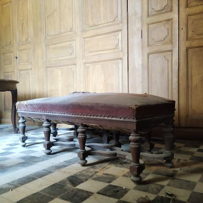 un banc au milieu d'une pièce au sol carrelé en damier