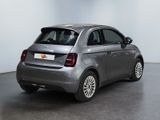the back of a silver car is parked in a white room