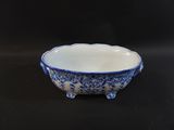 blue and white bowl on black table with black background