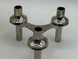 three metal pipes that are sitting on a white surface