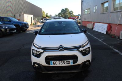 the front of a white car parked in a parking lot
