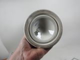 a person holding a white vase in their hand