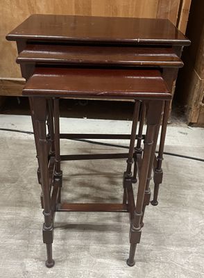 three wooden nesting tables sitting on top of a floor next to a dresser
