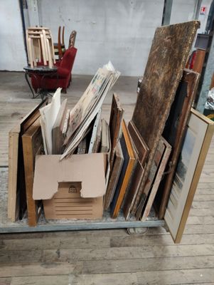 une boîte remplie de photos encadrées posée sur un plancher en bois