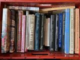 de nombreux livres dans une boîte rouge posée sur l'étagère