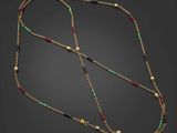un collier en or orné de perles multicolores sur fond noir