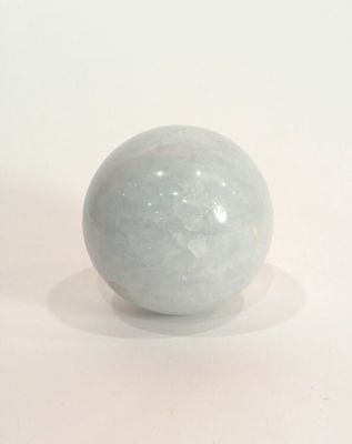 une boule de marbre blanc posée sur une surface blanche