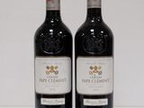 two bottles of red wine sitting next to each other on a table